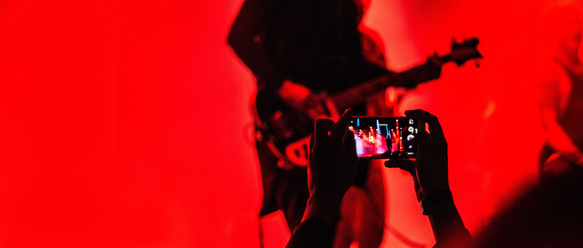 An audience member records a concert with his phone.