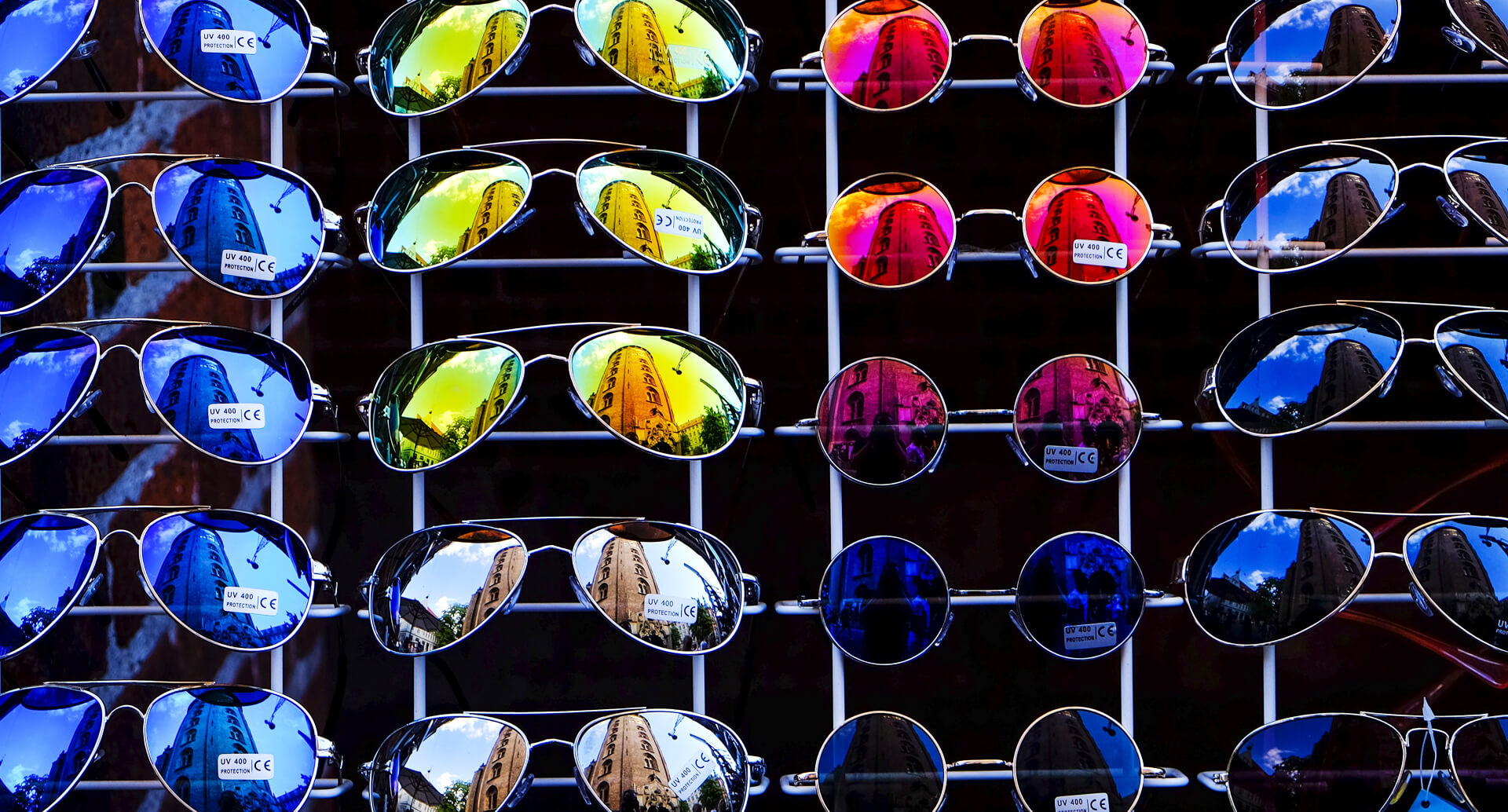 a display of sunglasses arranged by the colour of their lenses